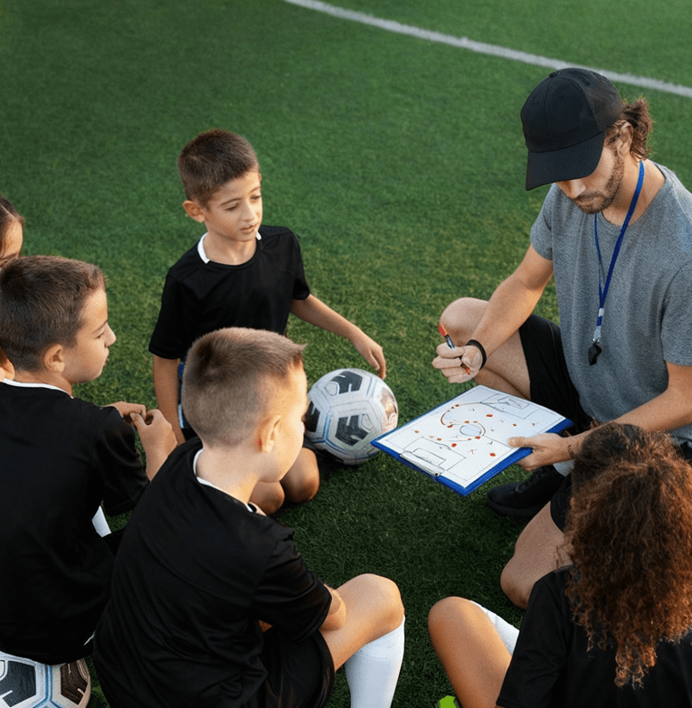 Entrenador de fútbol instruyendo a jóvenes